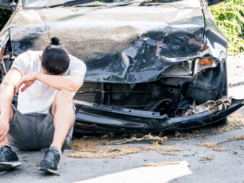 desperate man crying old damaged car after crash accident