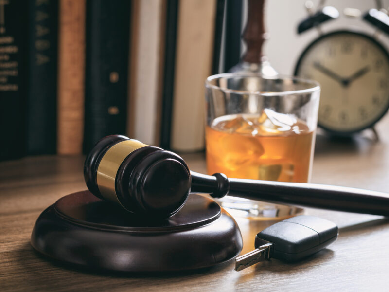 law gavel alcohol car keys wooden desk dark background