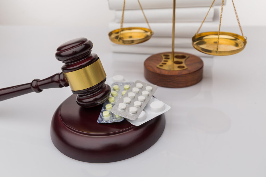 drugs law judge gavel colorful pills wooden desk