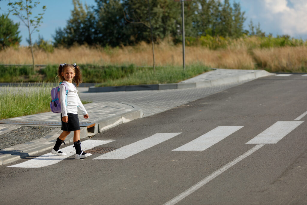 schoolgirl crosses road pedestrian crossing