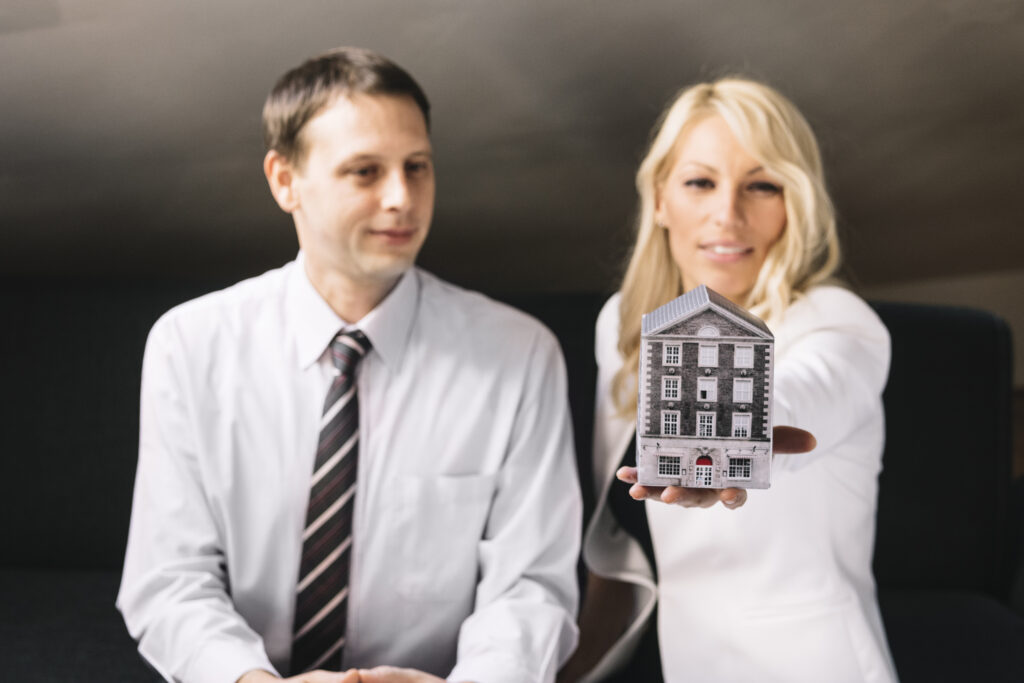 real estate agent holding toy house